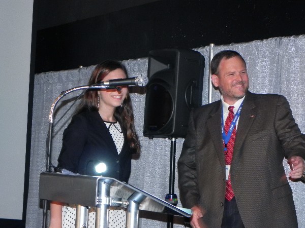 Scott Pence, director of the Science Fair Program, announces and greets the grand-prize winner of the Science Fair Competition in April. She received $2,000 in scholarship money.